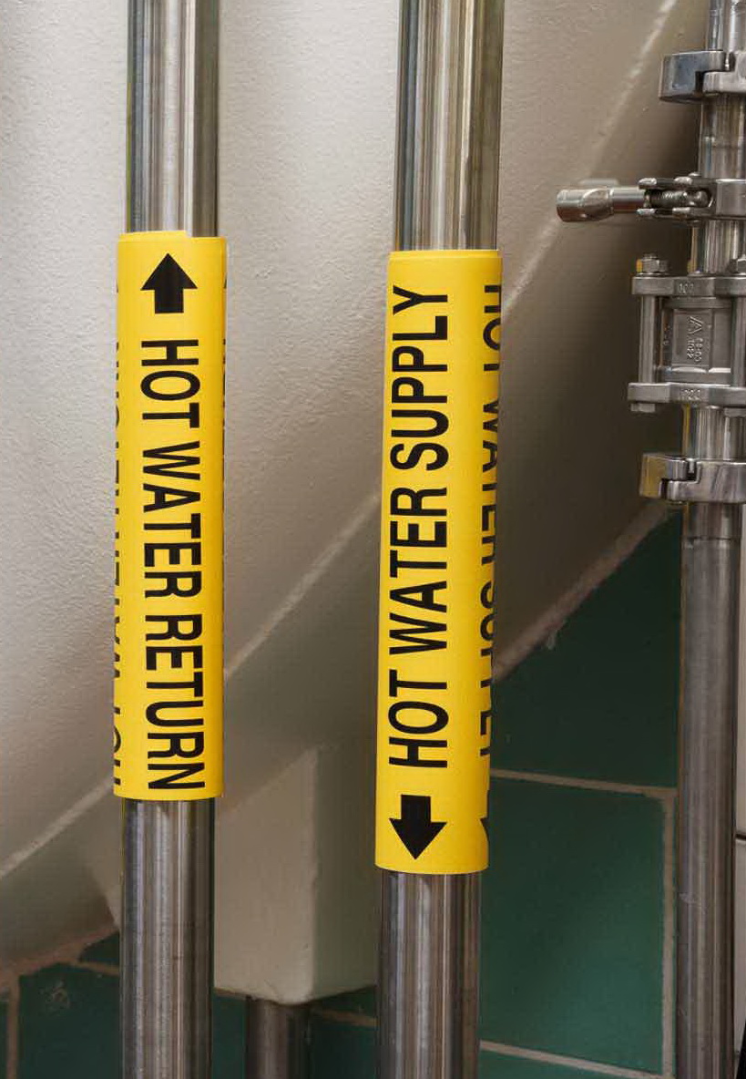 Two pipes with yellow Brady snap-on pipe markers